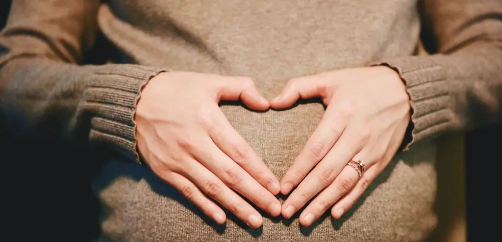 Image of pregnant women that holds her stomach