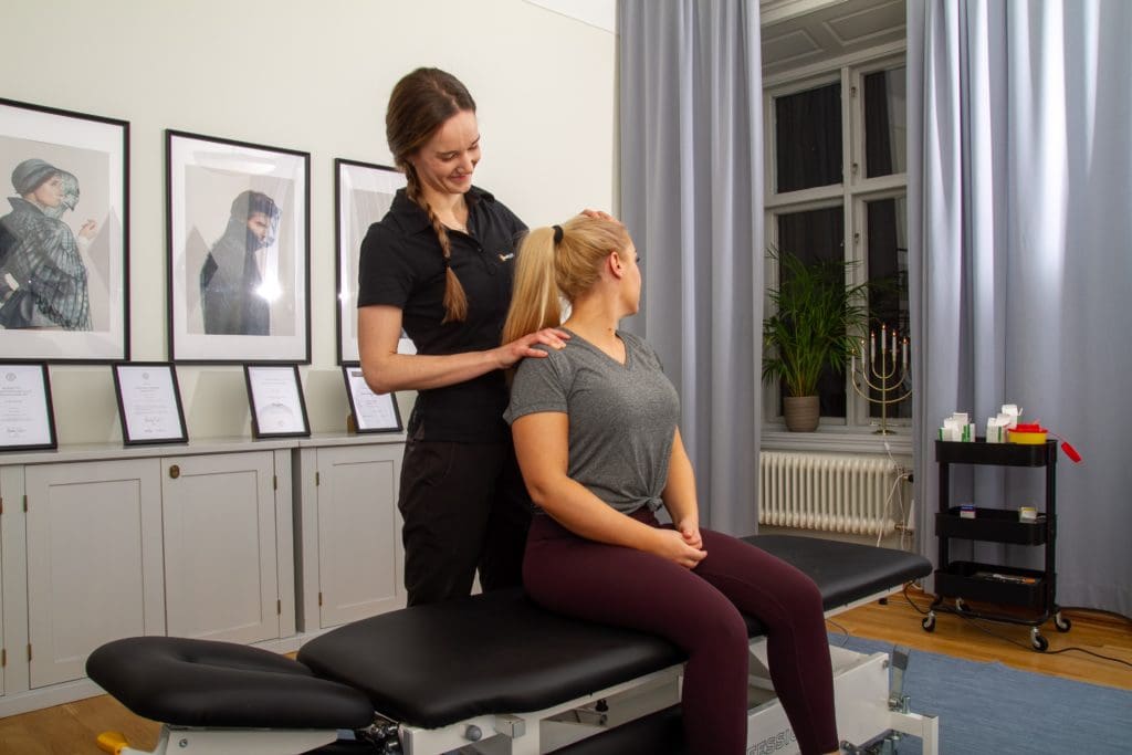 terapeut som behandlar en whiplashskada